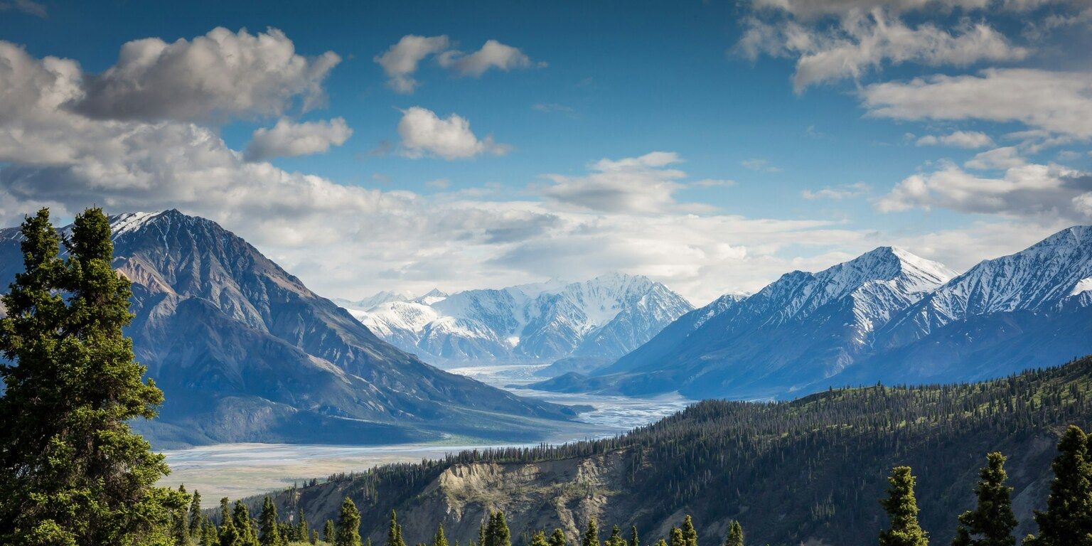 Snow-capped mountains with valley and forest in Kluane National Park, Canada